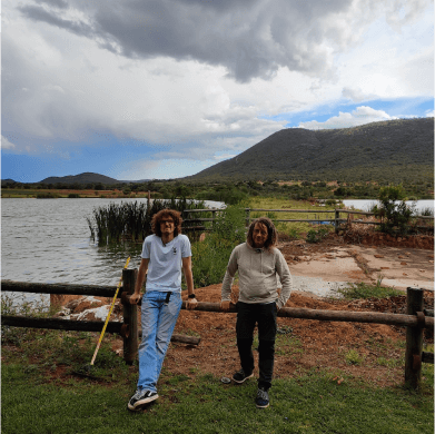 Tim Dresemann und Michael Knodt lehnen an einem Holzzaun in Südafrika.